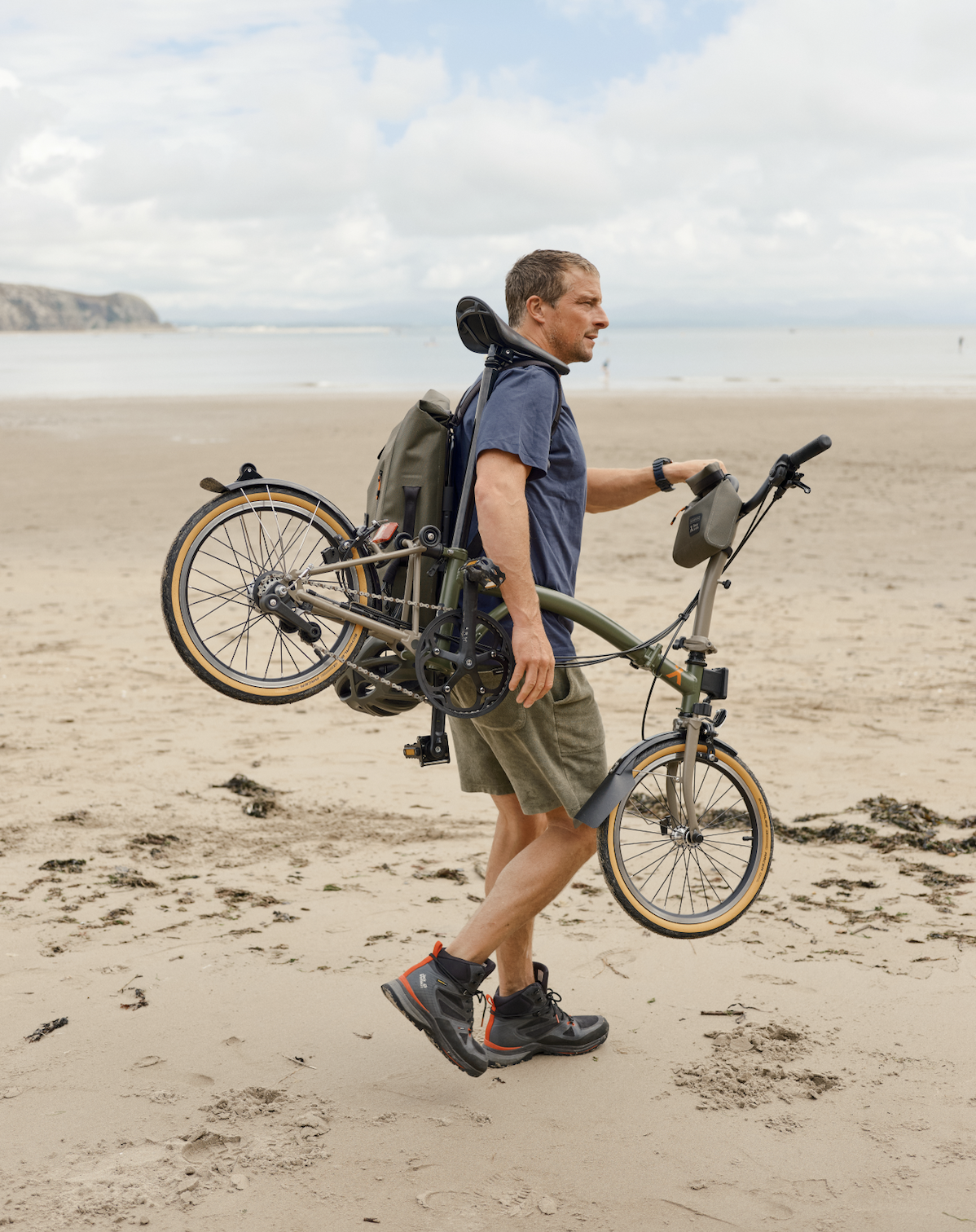 Bear Grylls holds a Brompton bike