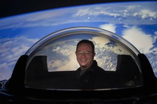 Inspiration4 astronaut Chris Sembroski tries out SpaceX's new cupola window for its Crew Dragon spacecraft before it was installed on the vehicle.