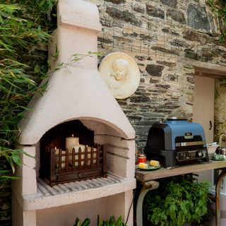 Ninja Woodfire Pro Connect XL and candle display in Anouska Lancaster's walled garden outdoor kitchen area