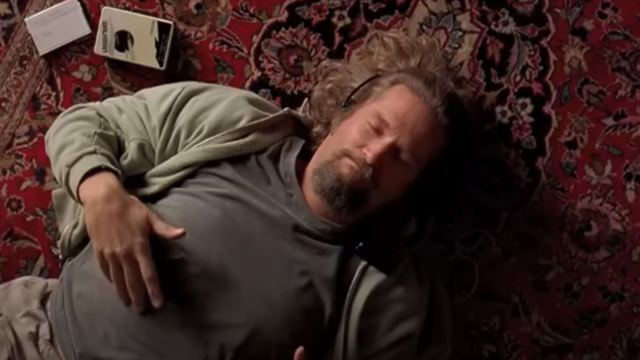 Jeff Bridges lying with his eyes closed on a nice carpet listening to a walkman.