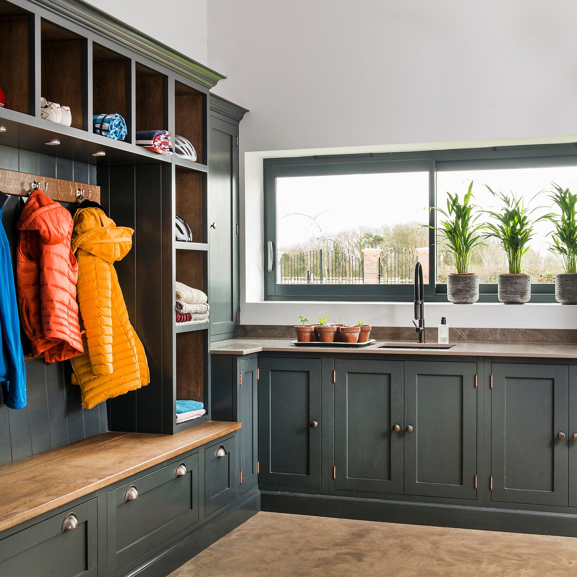 Laundry room with dark green cabinetry and built in storage