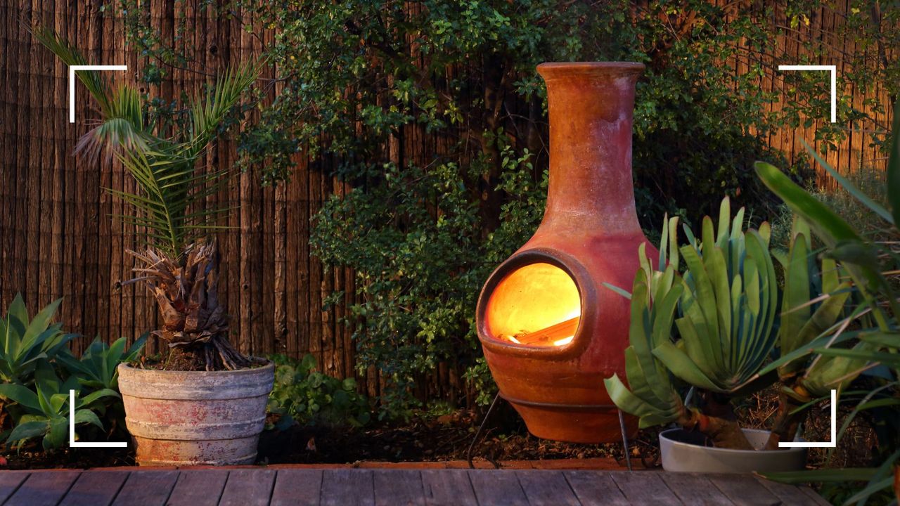 picture of ceramic chiminea in garden with a fire in it 