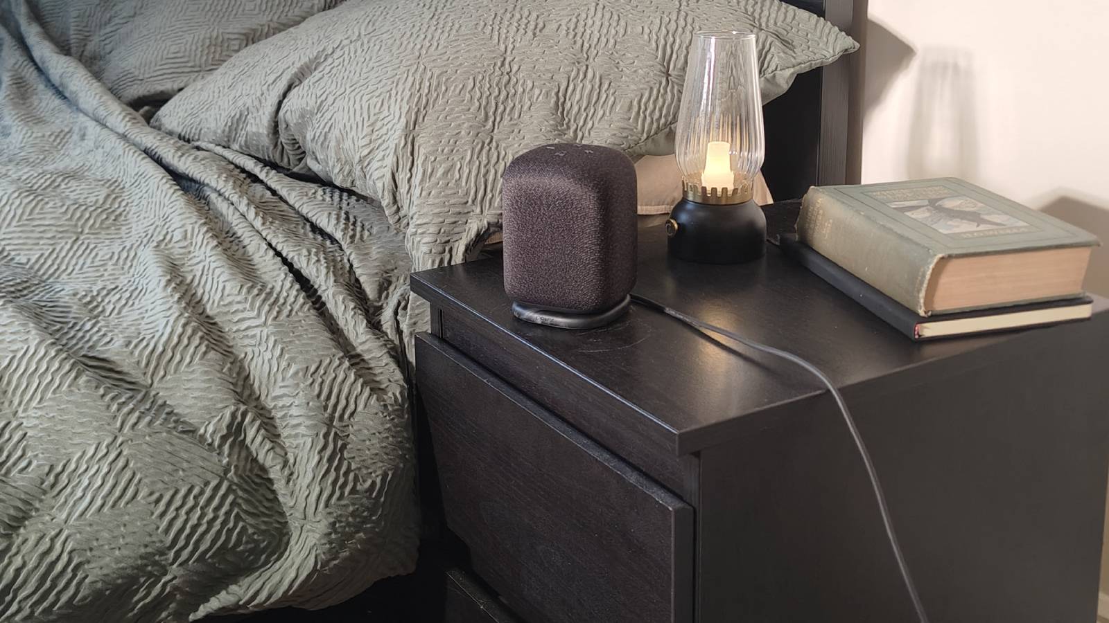 The Sony LinkBuds Speaker on a shelf beside a bed.