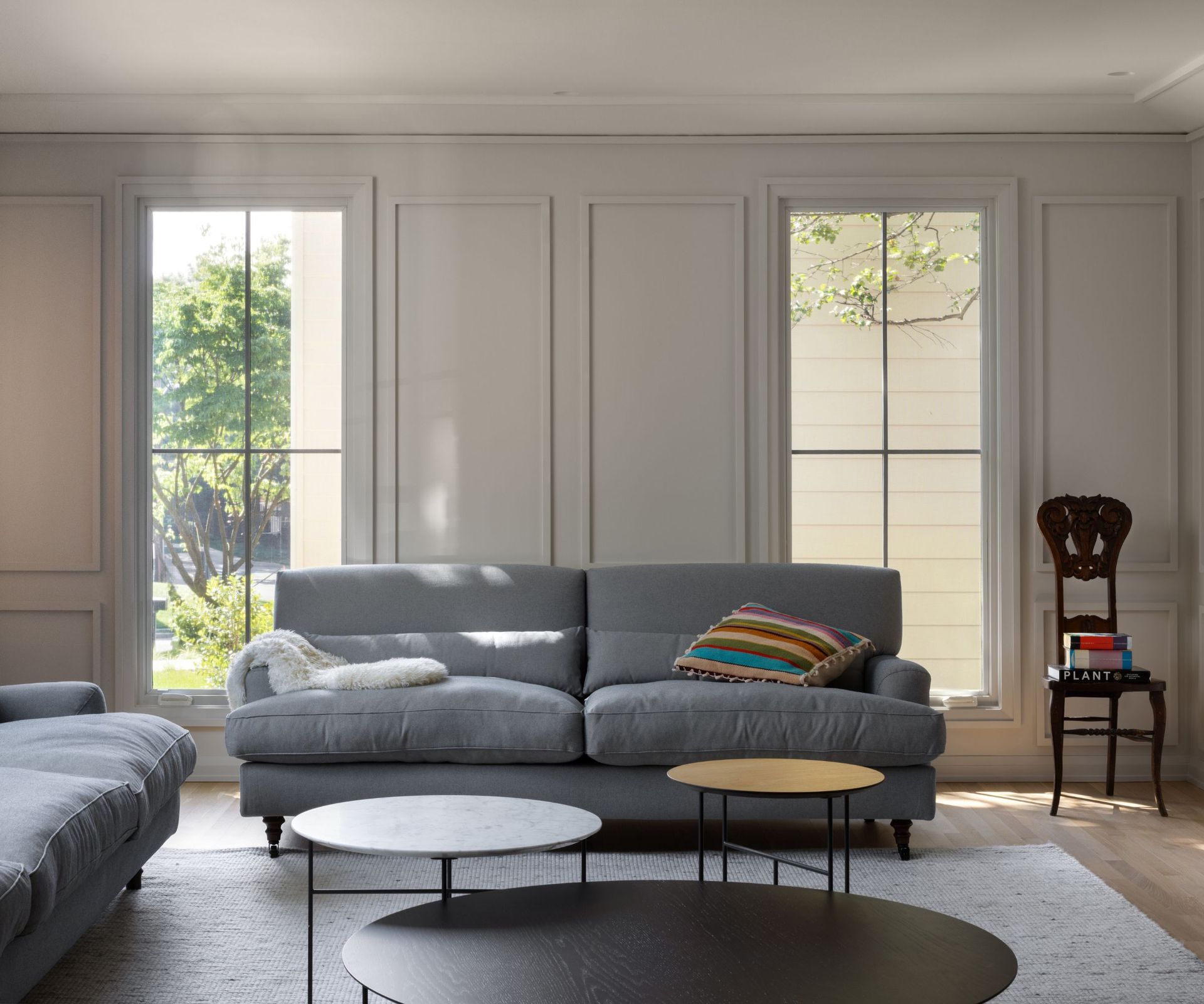living room with cream walls gray sofas natural wood floors bright cushion