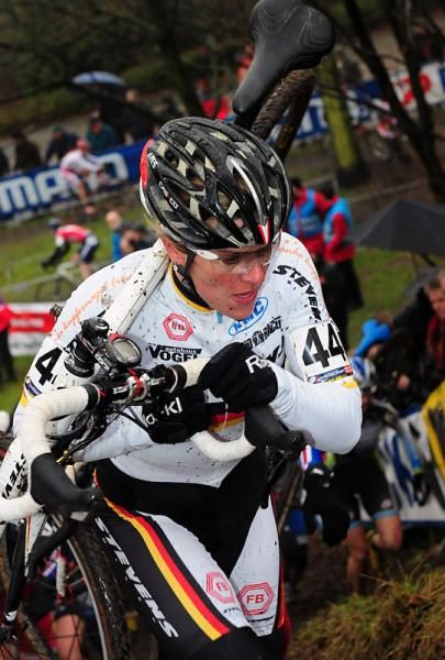 Hanka Kupfernagel shouldering her bike on the run-up.