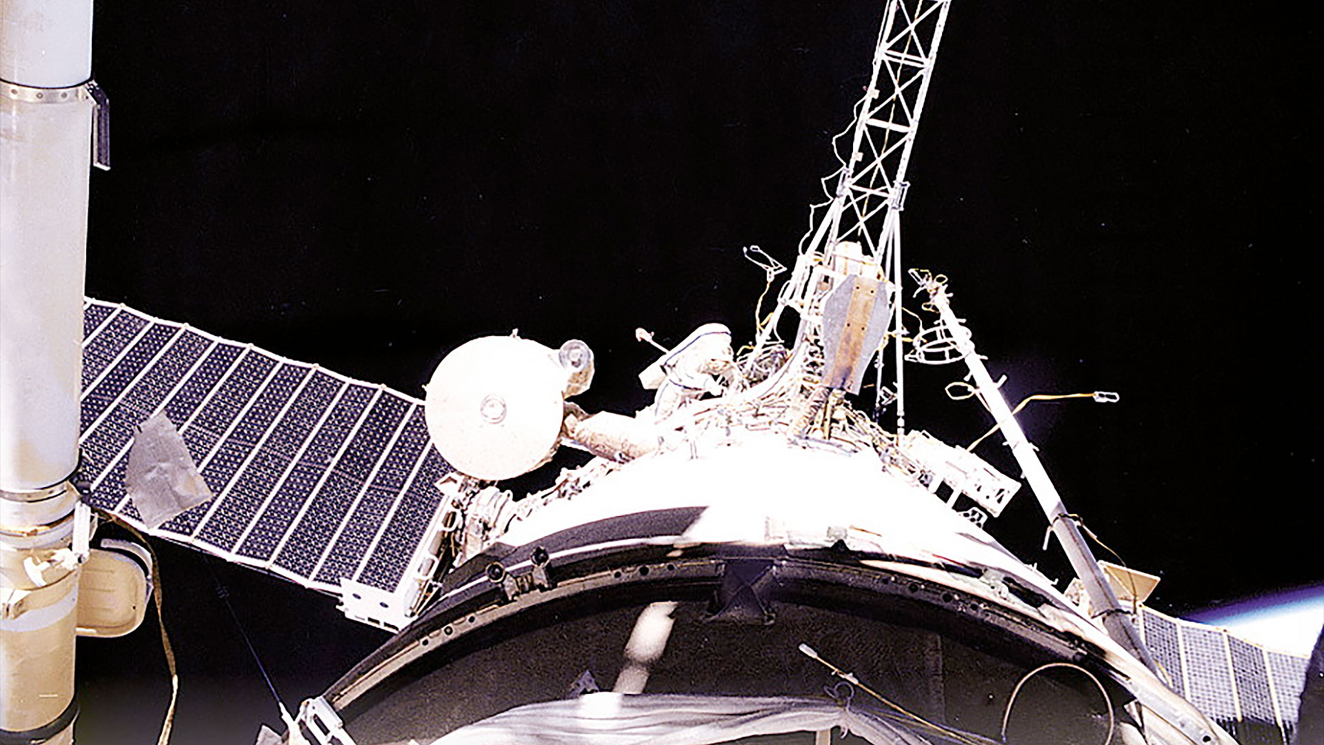 a cosmonaut is seen on a spacewalk outside a space station