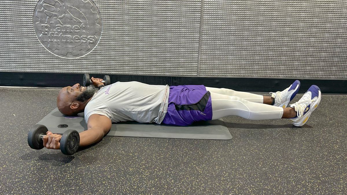 Teddy Savage starting a dumbbell floor chest fly to alternating knee tuck