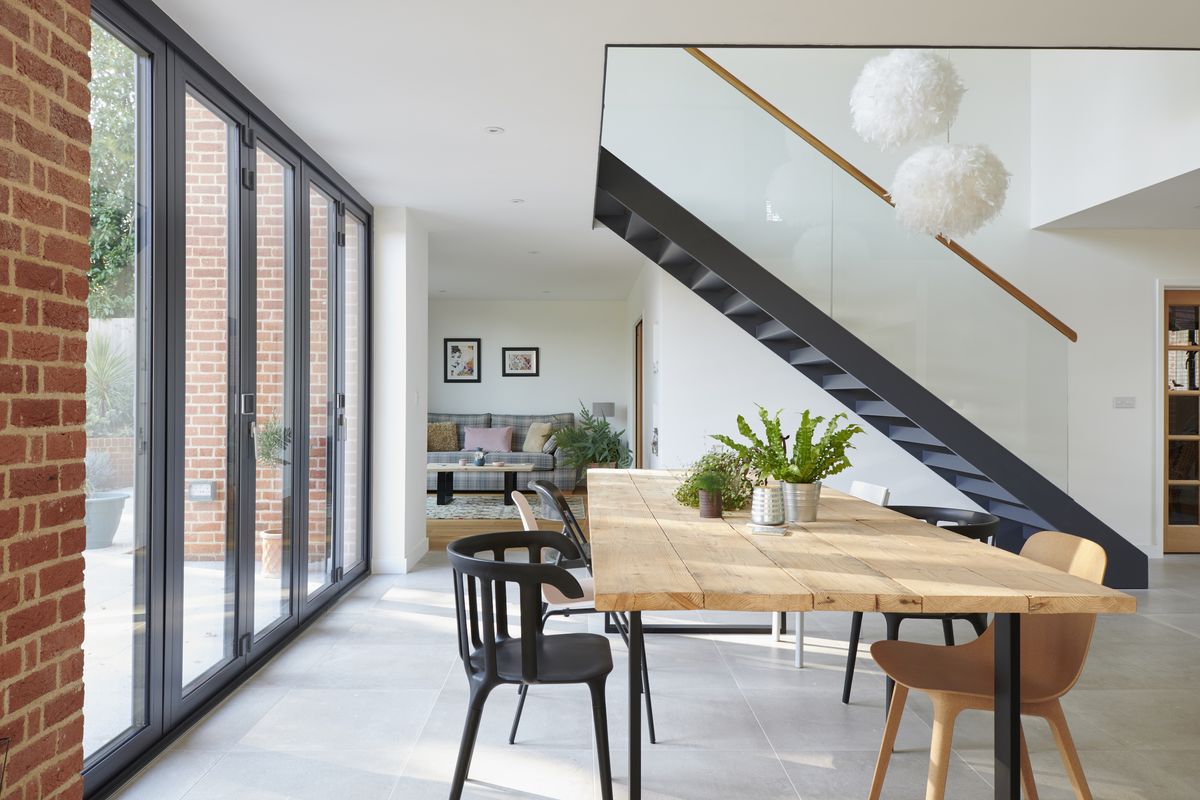 The stunning staircase which highlights the double-height void in the centre of the open-plan space is made from steel, painted in the same RAL shade as the windows and doors, while a more intimate snug &ndash; with its own set of patio doors &ndash; is carefully placed around the corner.