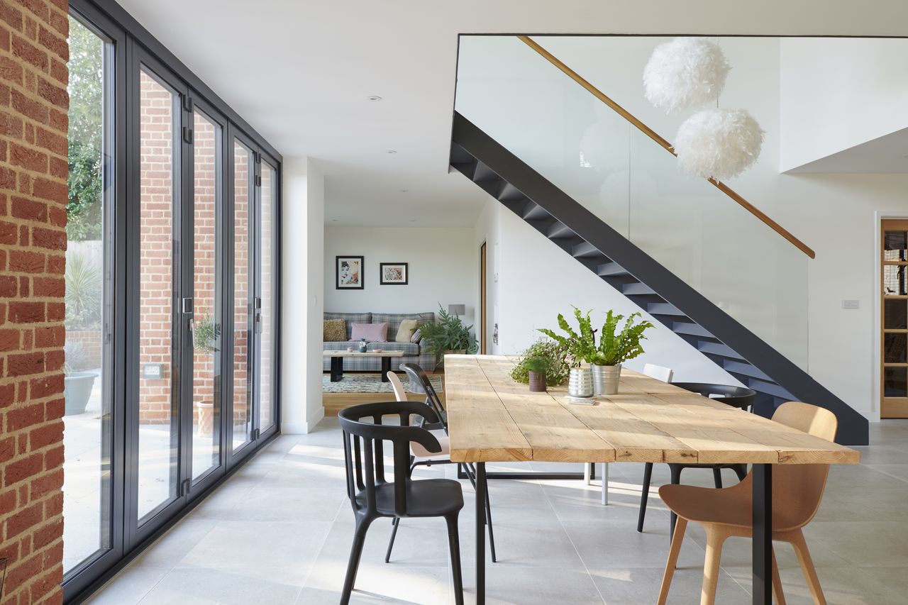 The stunning staircase which highlights the double-height void in the centre of the open-plan space is made from steel, painted in the same RAL shade as the windows and doors, while a more intimate snug &ndash; with its own set of patio doors &ndash; is carefully placed around the corner.