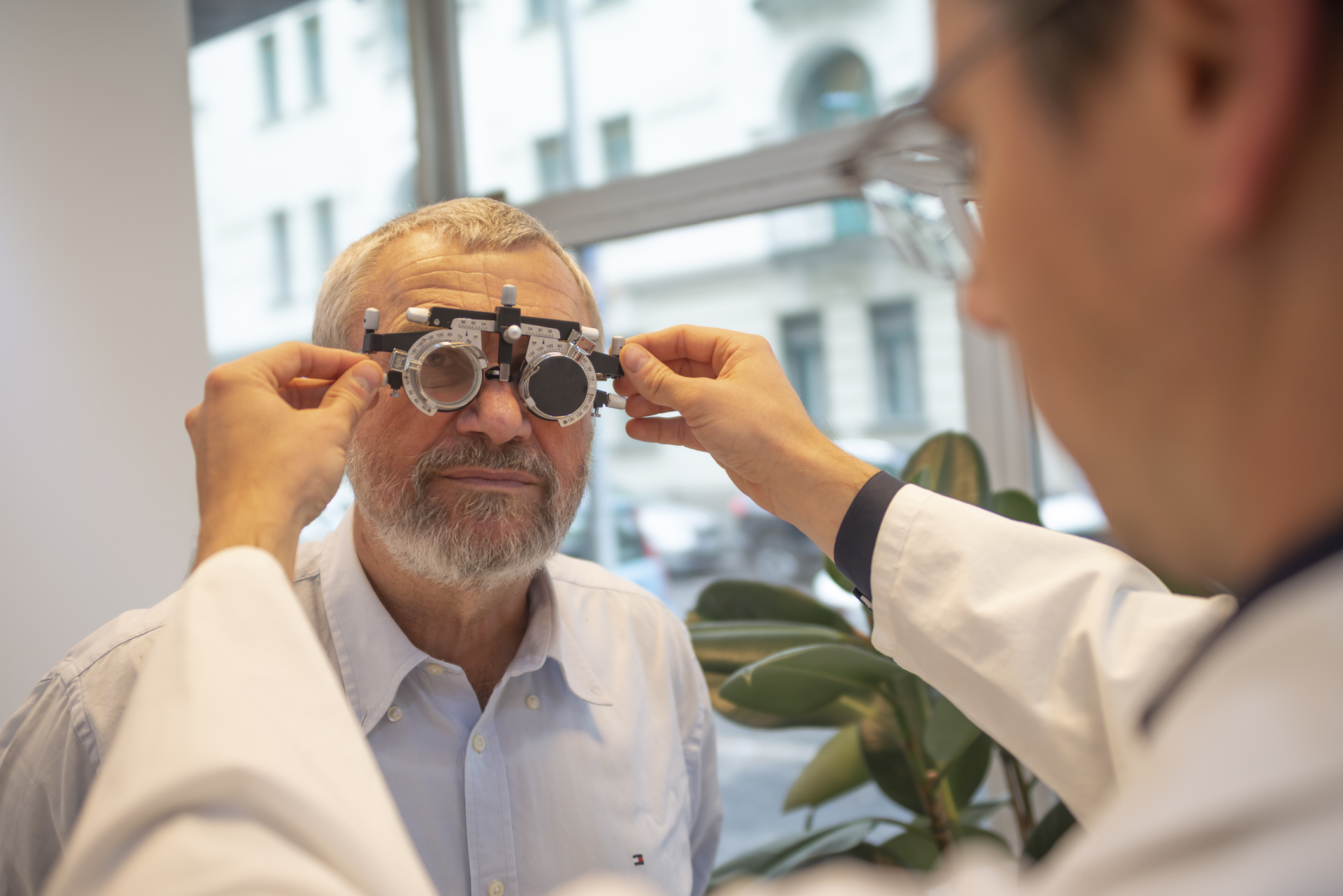 Optometrist with Optical Trial Frame Measuring the Eyesight of Senior Man, Optical Store - Healthcare and Medicine Concepts