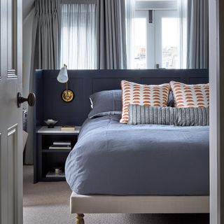bedroom with grey curtain and bedside table