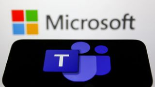The Microsoft Teams logo is shown on a smartphone, with the Microsoft logo displayed in the background on a wall