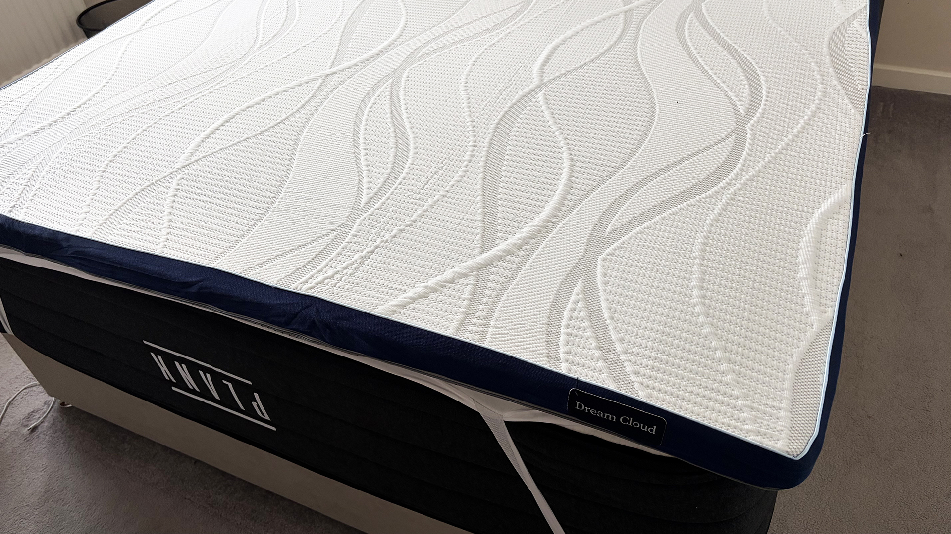 The DreamCloud Softer Mattress Topper on a bed in our reviewer's bedroom