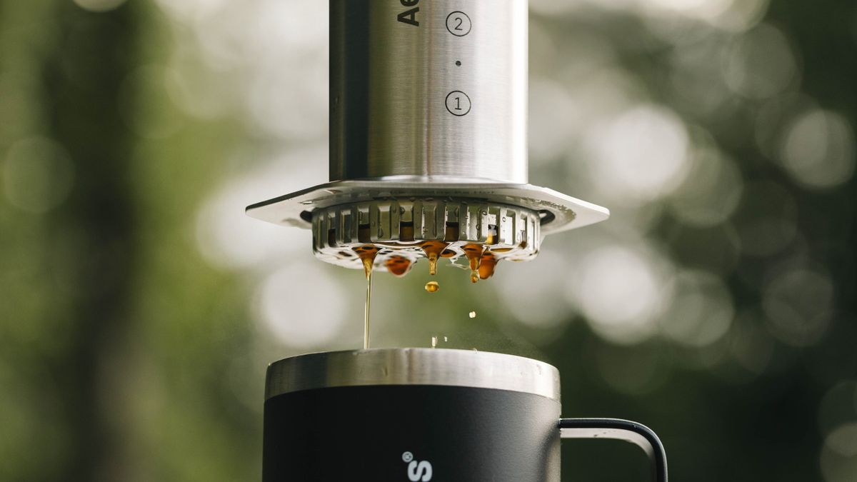 Brewed coffee dripping from AeroPress Steel coffee maker outdoors