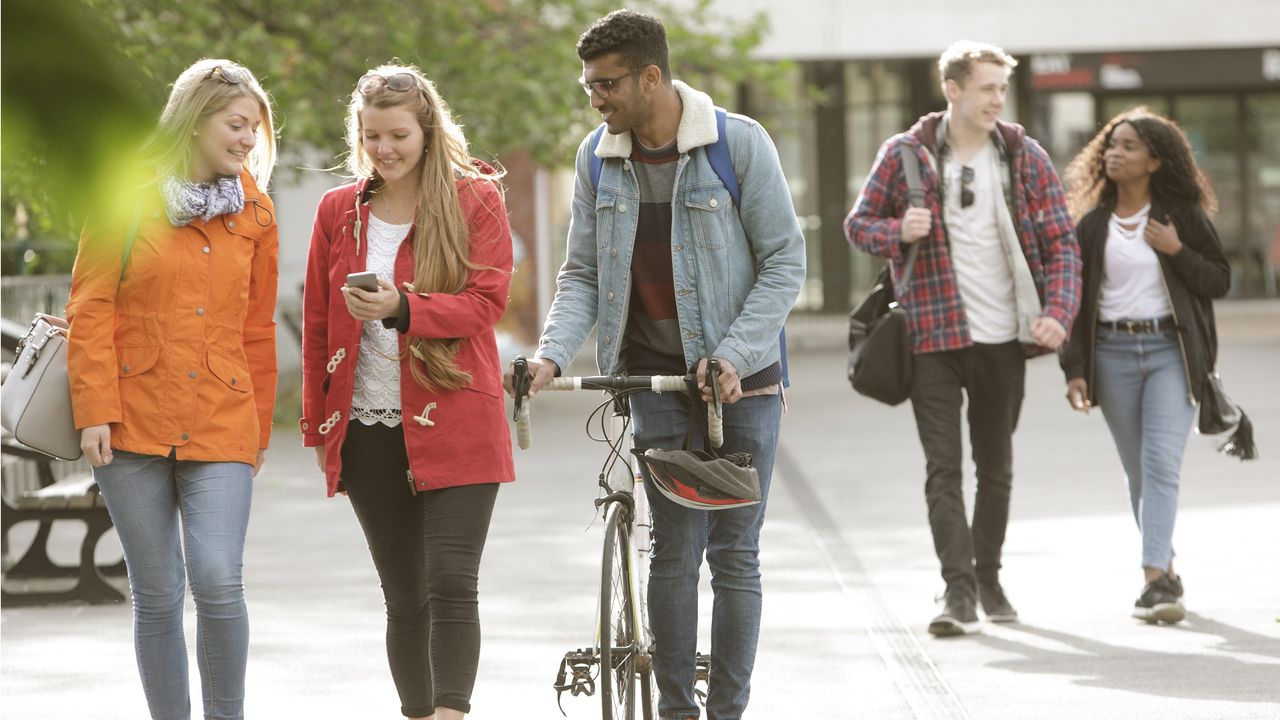 Some college students walk together on a college campus. 