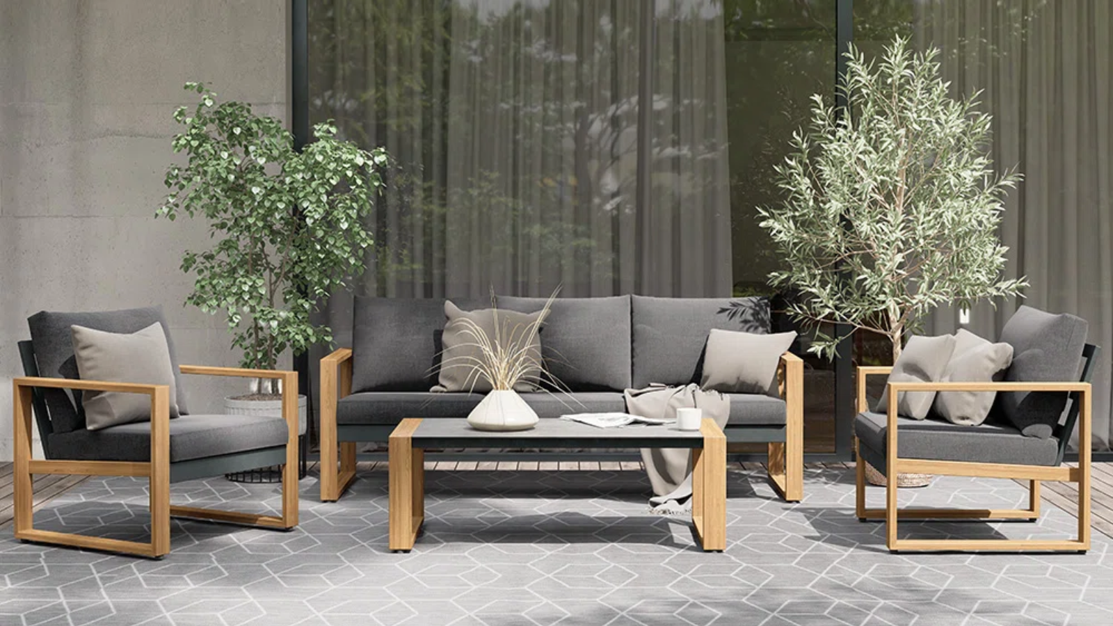 an outdoor seating area with gray furniture and a gray area rug and two small trees
