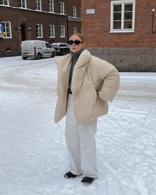 winter snow day outfits: white jeans and cream puffer coat