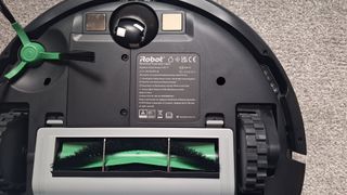 Roomba Combo Essential robot vacuum flipped over to show brushroll and side brush