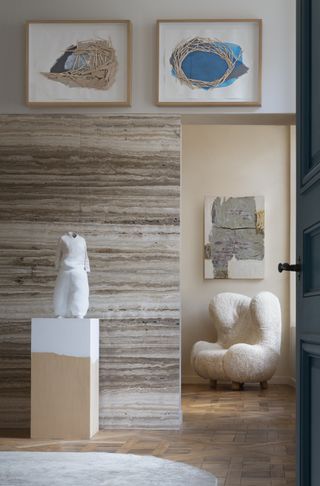Interior of Pierre Yovanovitch Paris showroom with textured wall, artworks and an armchair