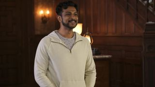 Utkarsh Ambudkar as Jay smiling in Woodstone Manor in Ghosts season 2