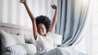 woman waking up, stretching and smiling