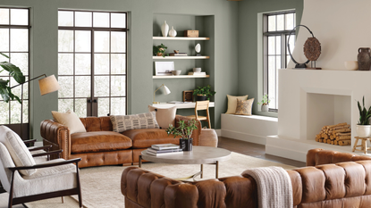 A living room with wooden furniture, bookshelves, and faded green walls.