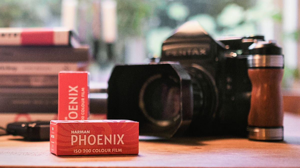 Harman Phoenix 200 120-roll film in front of Pentax 67 medium format camera on a desk