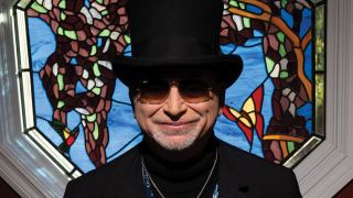 Toto's David Paich in a top hat standing against a stained glass window