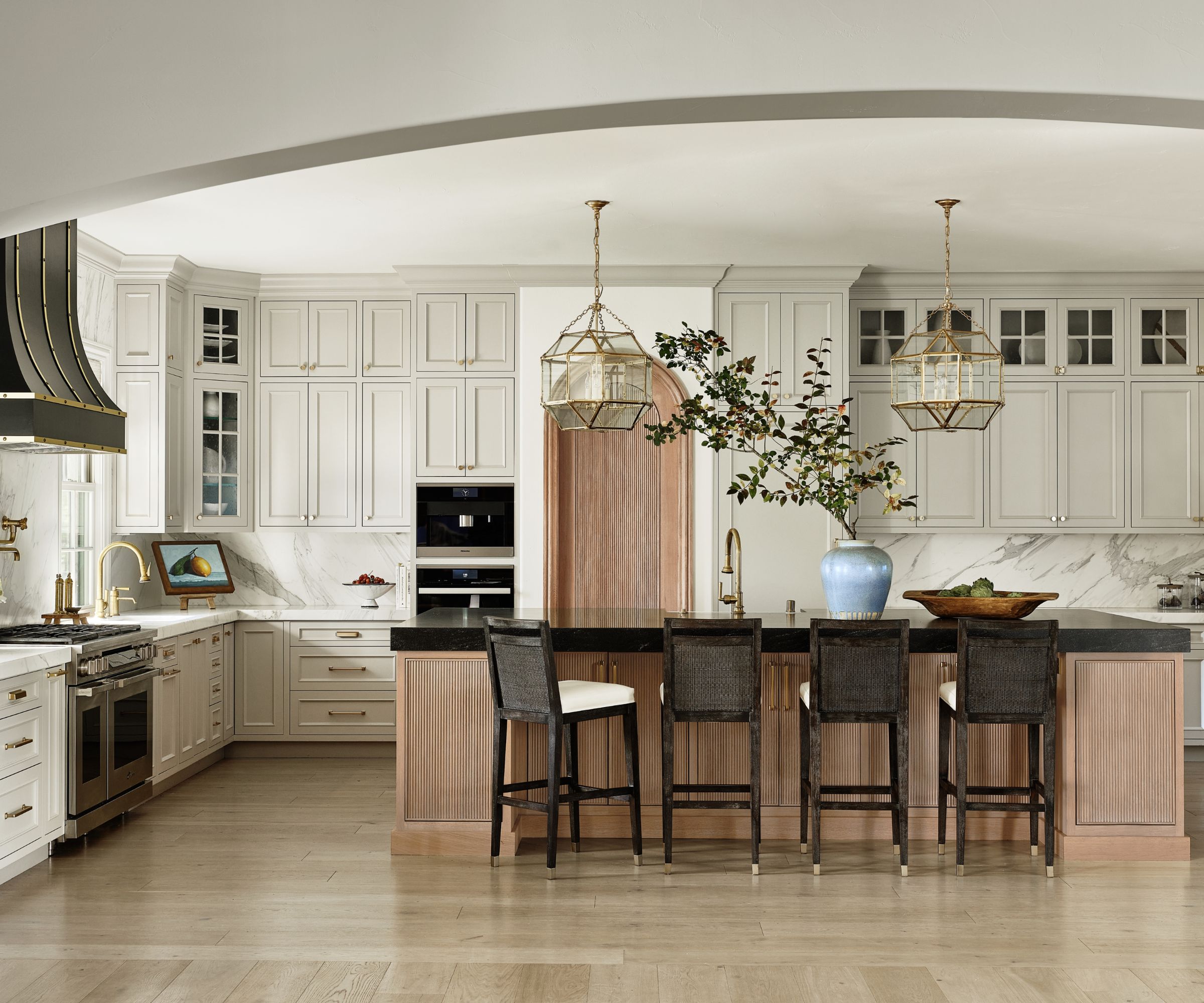 kitchen with cream units and black cooker hood with wood island detail