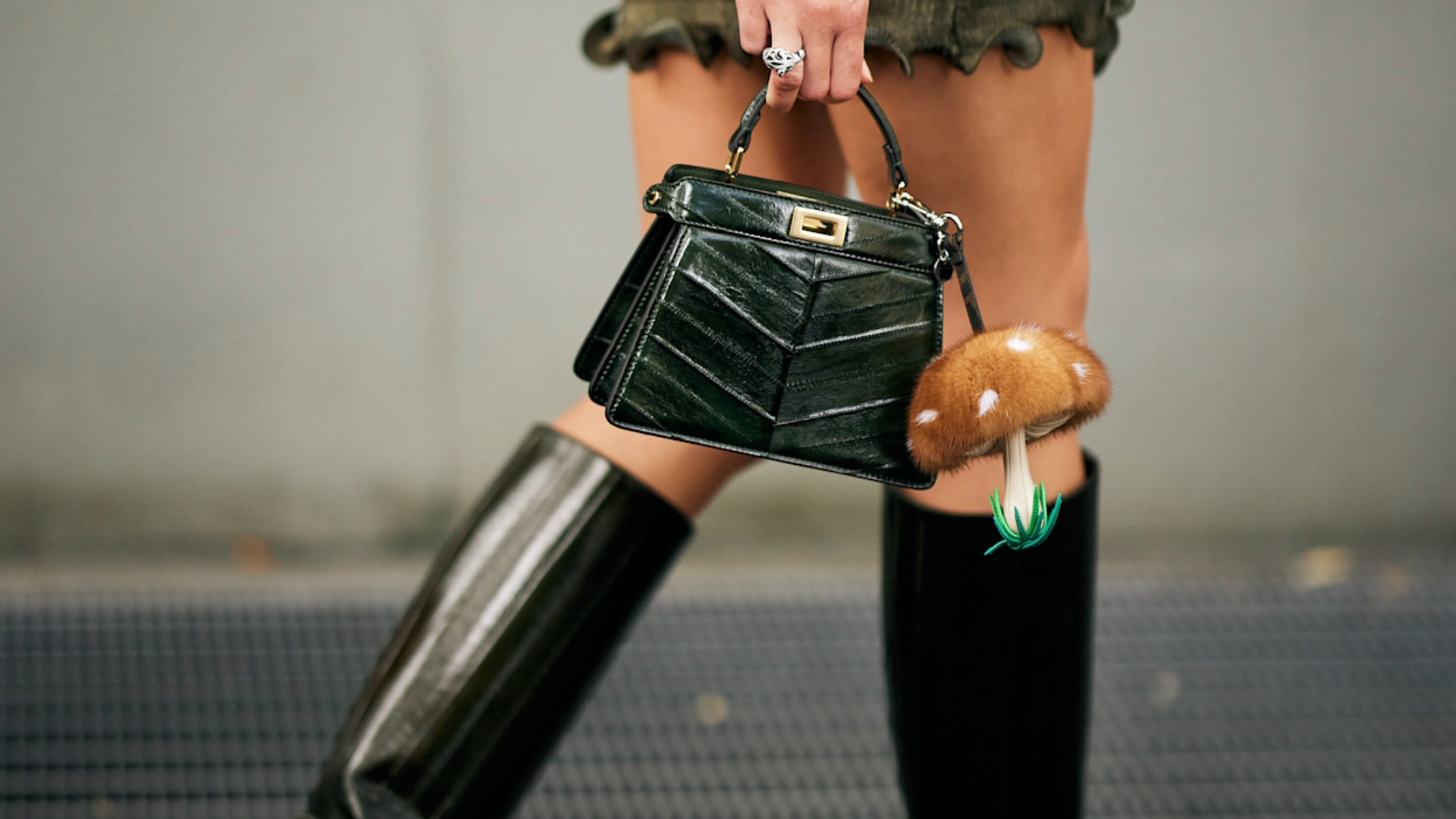 woman wearing a mini tophandle bag and black boots