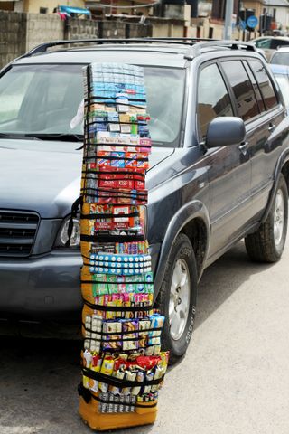 A portable carriers of confectionery items in-front of a car.