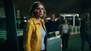 Carol looking worried as she stands next to a truck surrounded by people in Pluribus episode 1