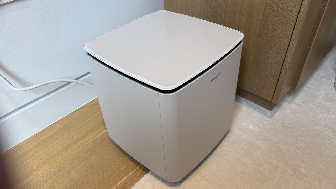 Bose Lifestyle Ultra Subwoofer in white smoke next to a TV stand