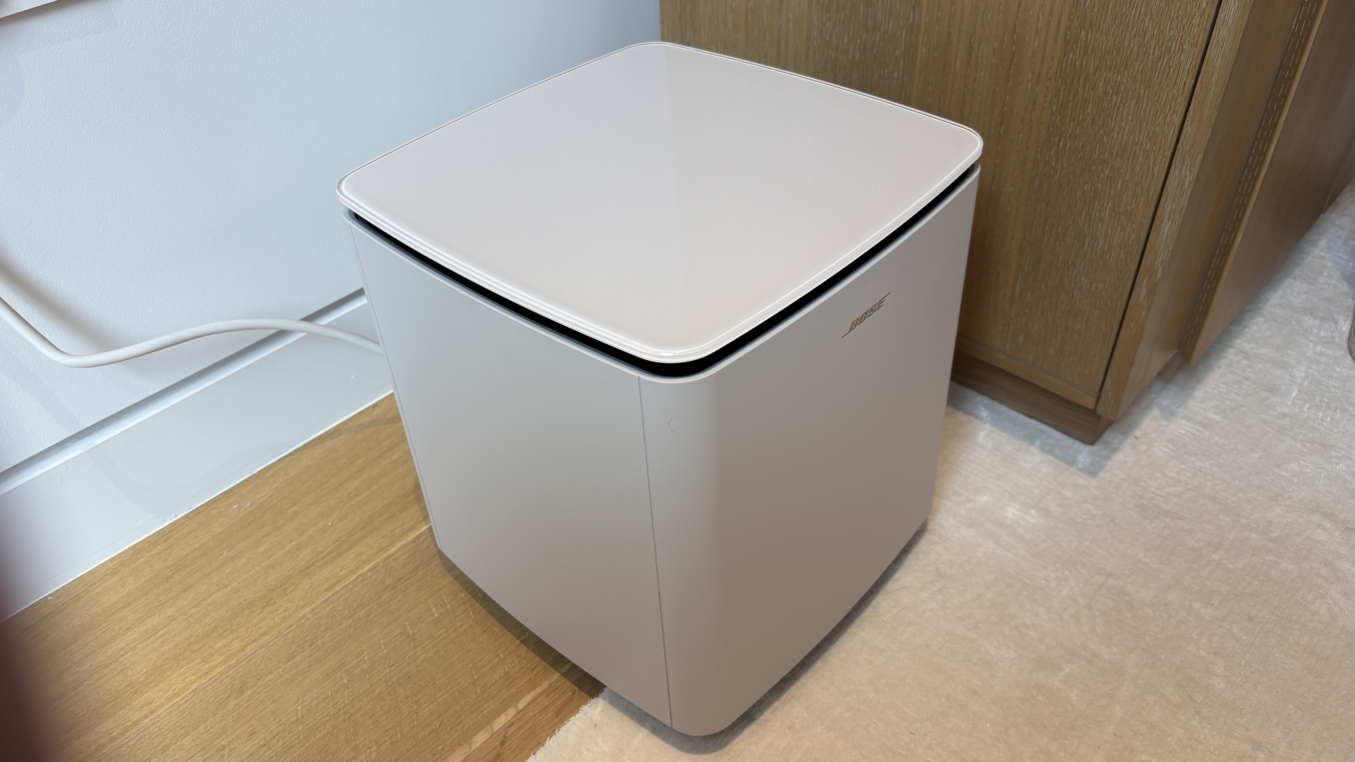Bose Lifestyle Ultra Subwoofer in white smoke next to a TV stand