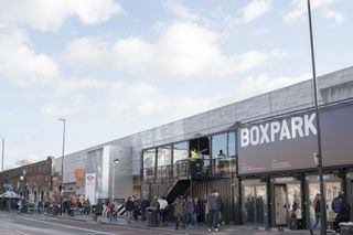 Shoppers walk through Boxpark, a pop-up shopping mall for fashion items constructed from recycling intermodal shipping containers, London, United Kingdom, October 29, 2017.