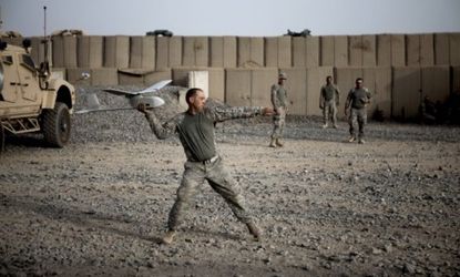 A U.S. soldier prepares to deploy a Raven unmanned surveillance drone in Afghanistan in 2010: The military is shifting its strategy to the cheaper, more reliant robotic airplanes.