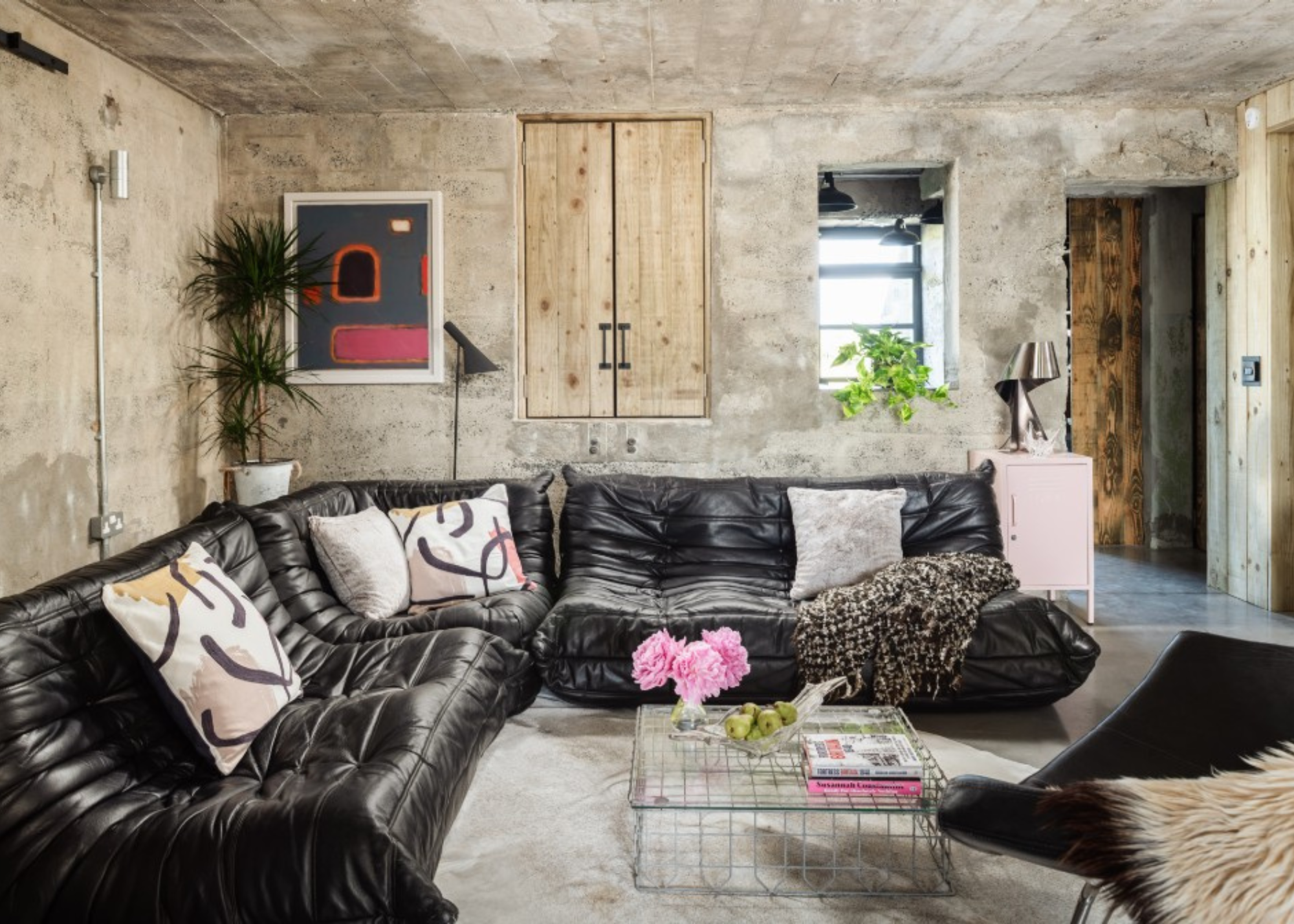 luxury modern living room with black leather togo sofa in a concrete bunker