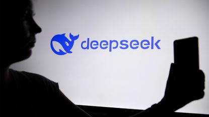 Silhouette of a man using smartphone in foreground with DeepSeek logo and branding pictured in background.
