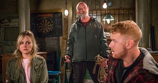 After goading Gary, Phelan suddenly rears up and pulls a gun on him and Sarah, and then ties them up. Then he heads off to No.11….
