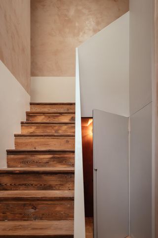 Wooden staircase next to open door.
