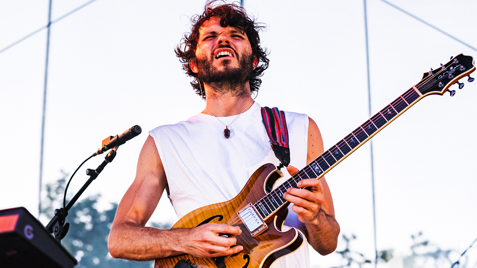 A photo of Goose guitarist Rick Mitarotonda performing onstage outdoors