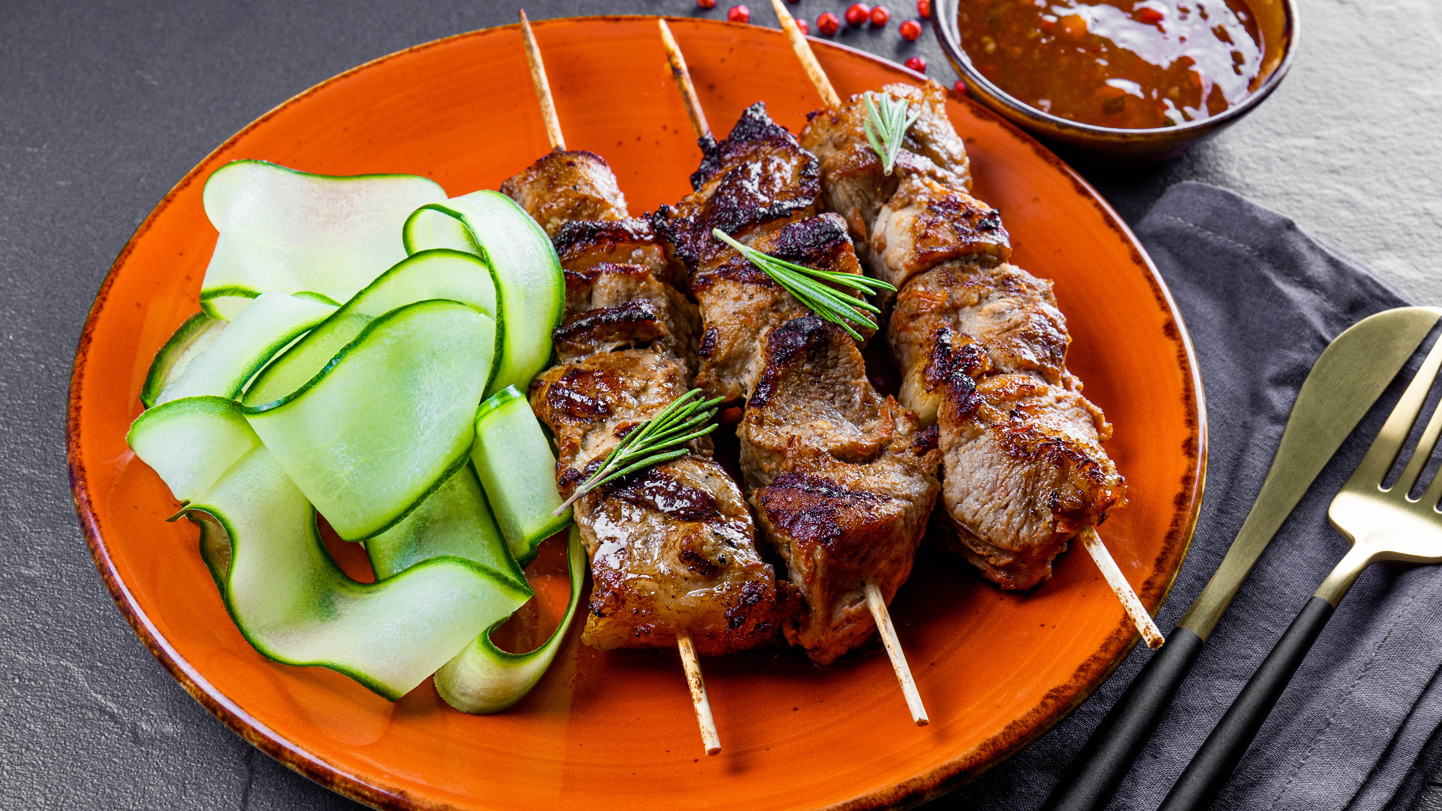 Grilled meat on skewers in a plate with salad