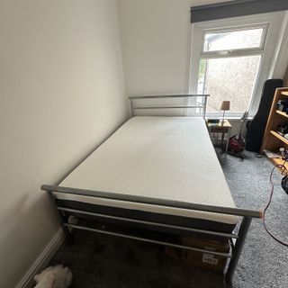 The Emma NextGen Premium mattress on a grey metal beframe in a guest bedroom