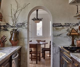 Spanish revival kitchen with an arched doorway into the breakfast nook