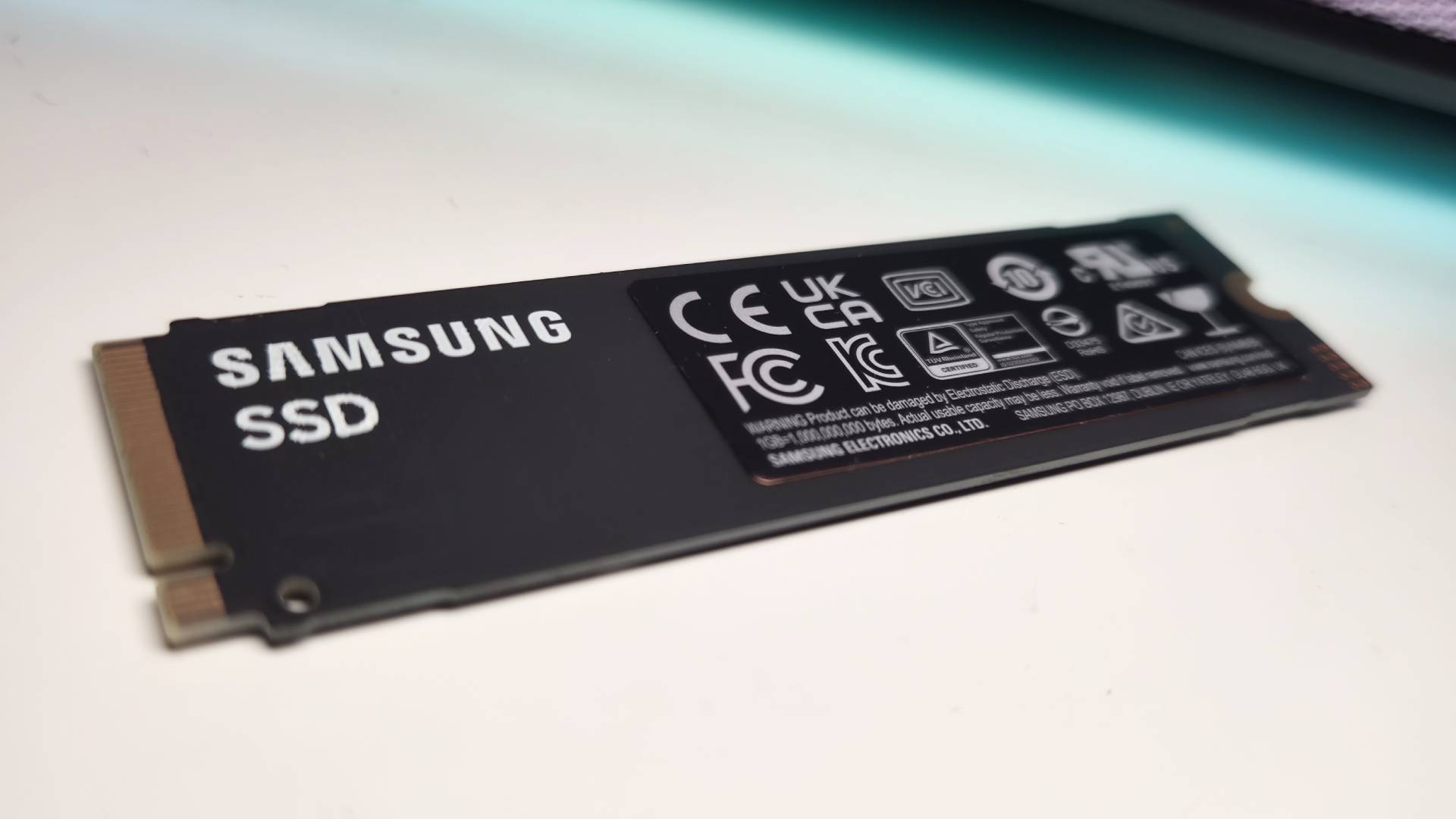 Close up of the new Samsung 990 SSD sitting on a white desk.