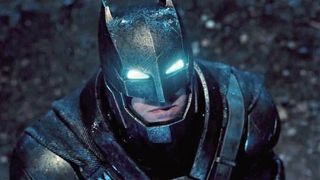 Batman blickar uppåt mot något, där ögonen i hans dräkt lyser i en ljusblå neonfärg.