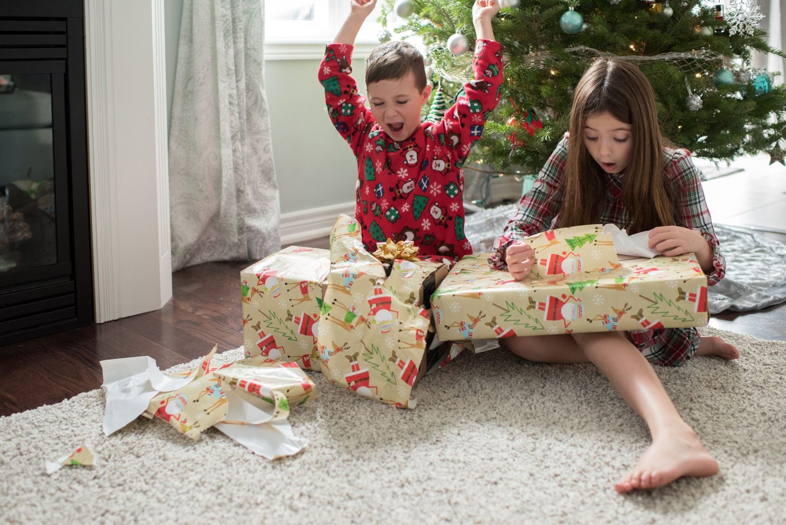 Their christmas. Распаковываем новогодние подарки. Дети распаковывают подарки. Дети распаковывают новогодние подарки. Ребенок разворачивает подарок.