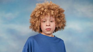 Portrait of a boy in front of a blue background