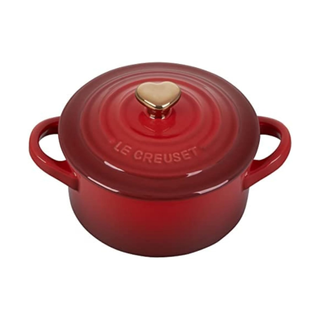 le creuset mini round dutch oven in cherry red with a heart handle on the lid