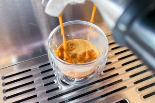 An espresso being poured into an espresso glass